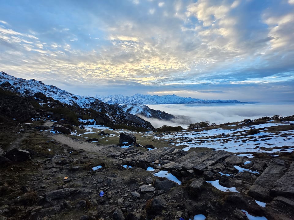A rocky ridge trail with mountains and cloud at sunrise